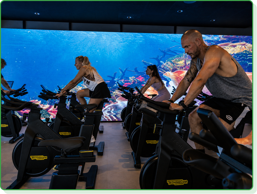 Spinninghold foran en LED-væg i et fitnesscenter i Fredericia